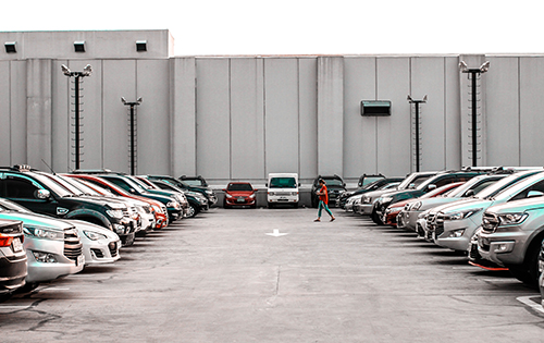 image of woman walking across parking lot