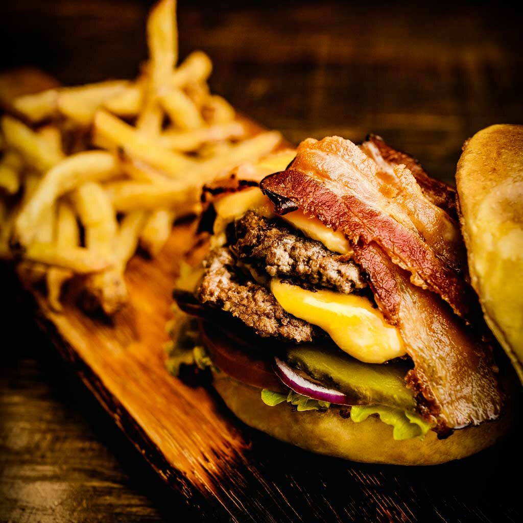 image of bacon cheeseburger and fries on a wooden board